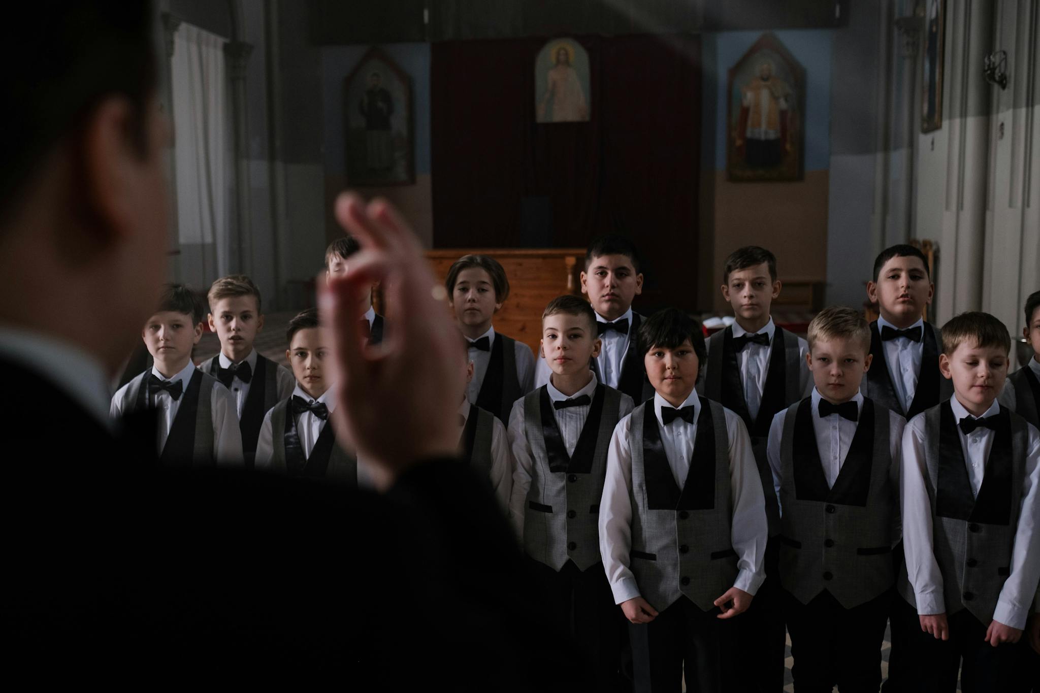 Boys choir dressed in elegant uniforms performing inside a church.